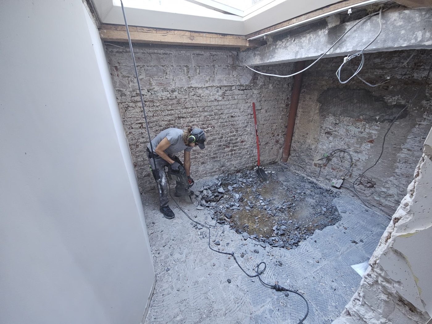 Baptiste Mercier en train de démolir une dalle avant rénovation, Uccle